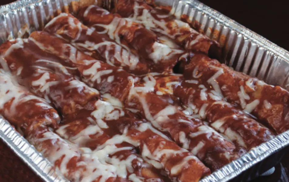 Tray of enchiladas with red sauce and melted cheese